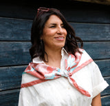 Woman wearing Fresh Beauty large silk square scarf tied over shoulders