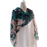extra large square silk and cashmere shawl in deep green and soft pink with Japanese orchid design angled view draped over one shoulder