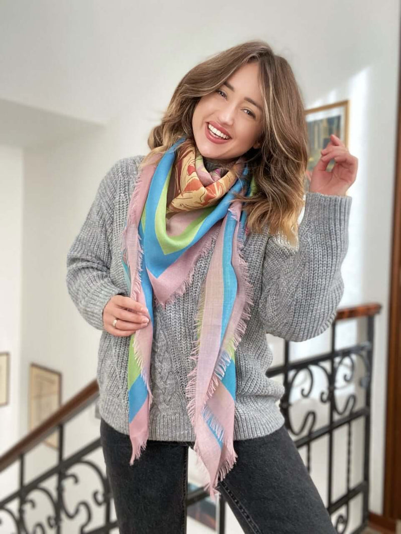 woman wearing Louis Jane French Roses oversized  cashmere and silk square scarf looped around in pink, green and blue colours 